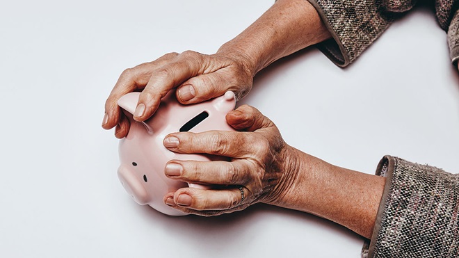 elderly_persons_hands_on_a_piggy_bank